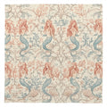 A square textile or fabric panel featuring a repeating mermaid and coral sea-plant pattern on a warm cream background. The mermaids have pink hair and blue tails, with coral in muted pink and blue-gray tones.
