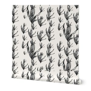 A roll of wallpaper featuring a repeating black botanical leaf pattern on a warm off-white background, shown standing upright with a slight perspective angle.