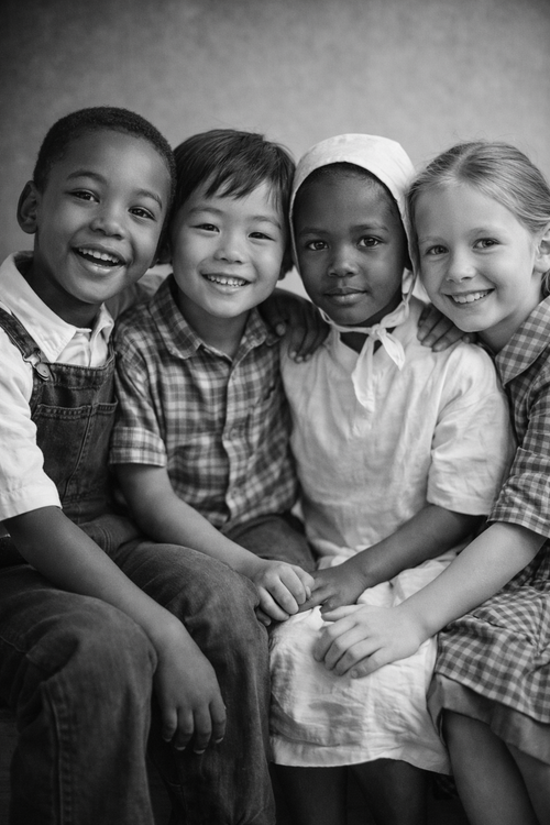 Black and white photo of four children sitting together