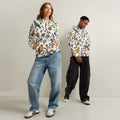 Two people wearing colorful floral-patterned hoodies against a plain background