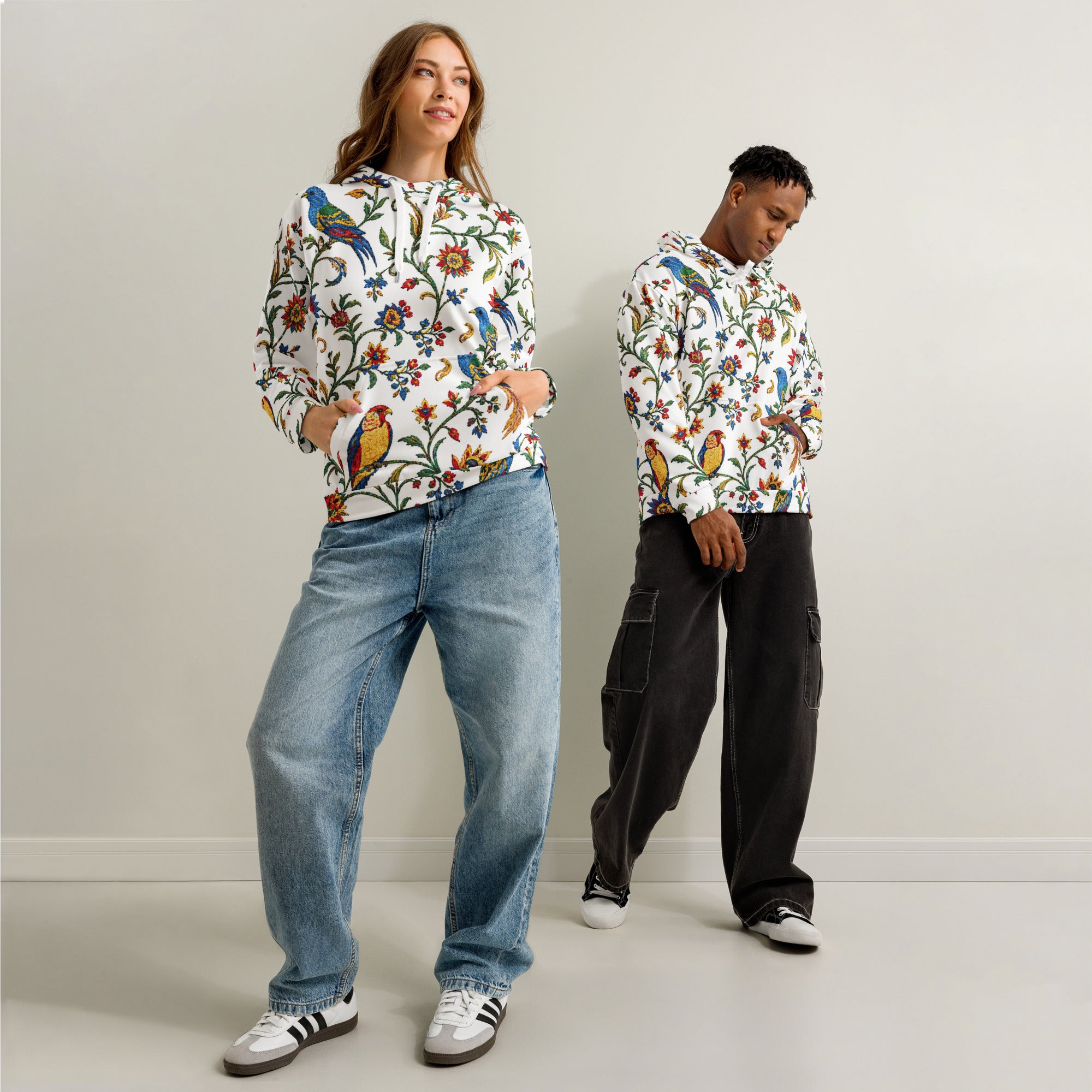 Two people wearing colorful floral-patterned hoodies against a plain background