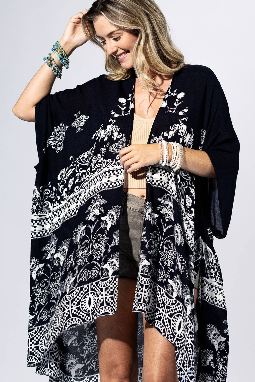 Woman wearing a black floral kimono against a light background