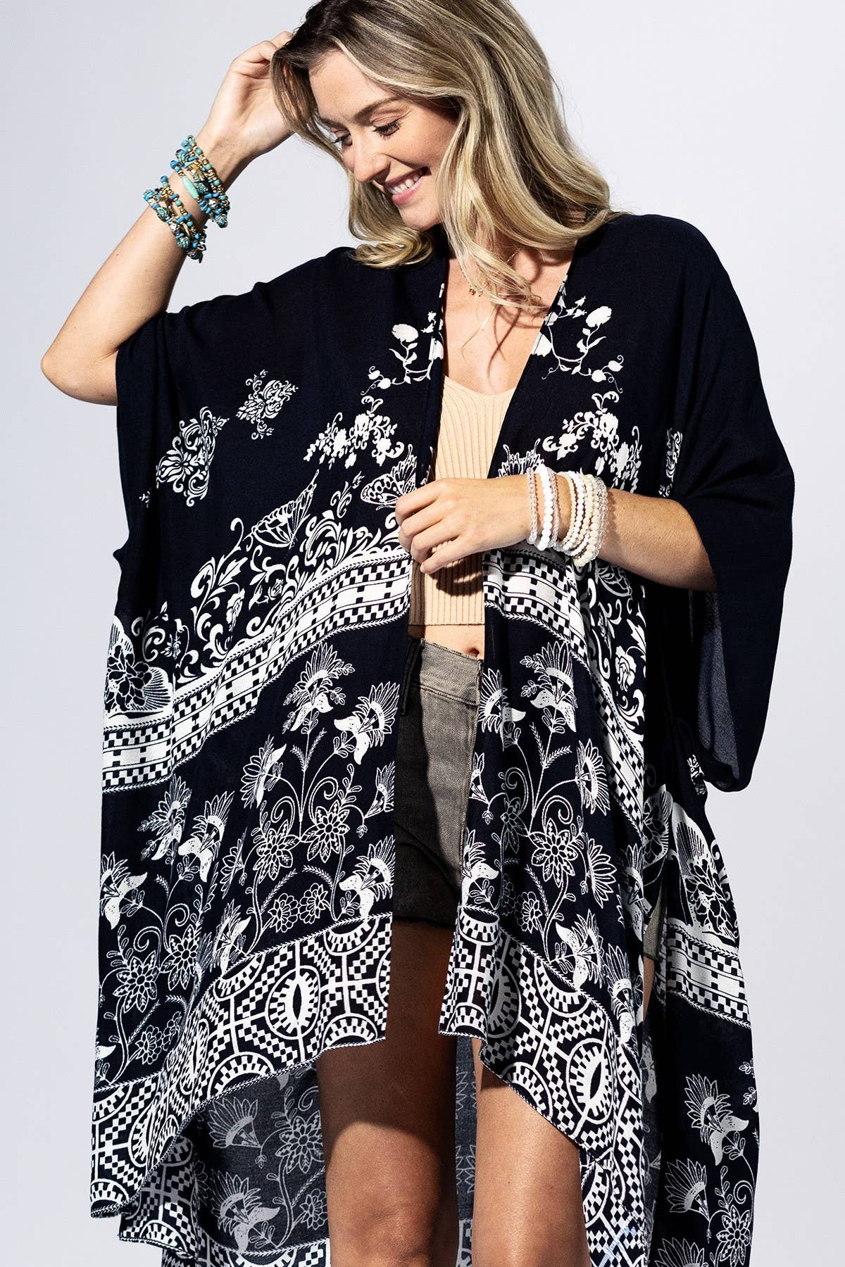 Woman wearing a black floral kimono against a light background